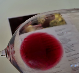 vue d un verre de vin rouge de prés. le vin forme une tache rouge dans le verre.